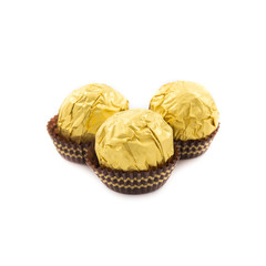 Sweet chocolate balls with almond wrapped in gold foil paper on white background