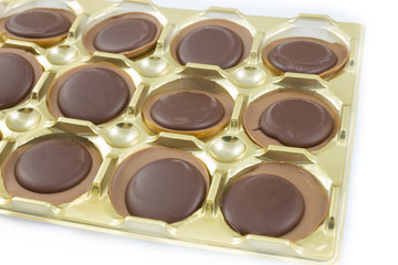 Chocolates in a gold box on white background