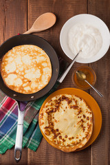 homemade pancakes on a frying pan with sour cream