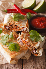 Mexican street food: chimichanga with minced meat close-up. Vertical
