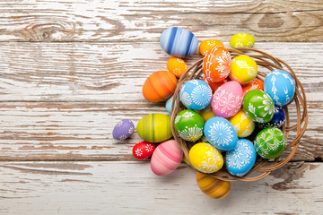 Easter eggs in basket placed on wooden planks