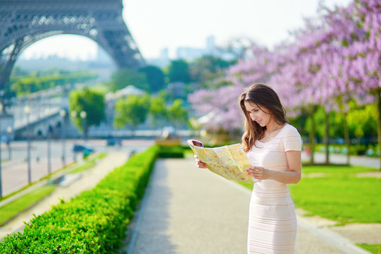 Woman with map near the Eiffel tower in Paris