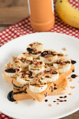 Obraz na płótnie Canvas Sandwich peanut butter with banana and muesli crisp with chocola