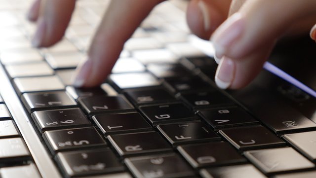 Modern woman in office typing on black keyboard keys slow tilt 4K 2160p 30fps UltraHD footage - Business female using laptop for typing text document 4K 3840X2160 UHD video 