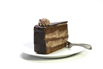 Slice of chocolate cake on white plate with fork.