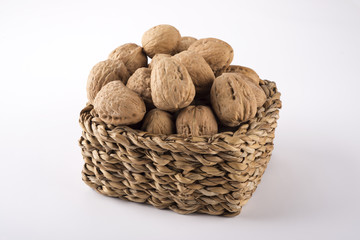 Basket of walnuts on white background