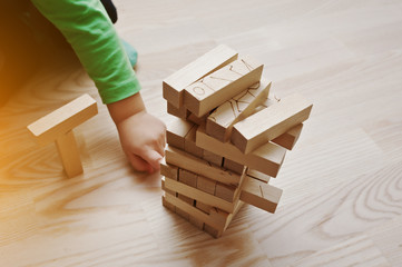 Hand of baby who played developmental game of wooden blocks lumb