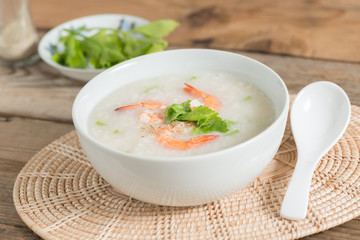 Rice porridge with shrimp in white bowl.