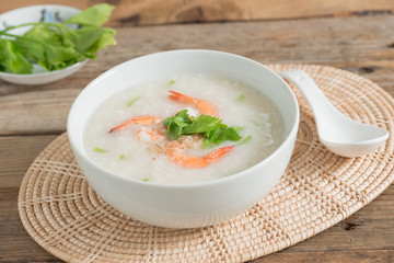 Rice porridge with shrimp in white bowl.