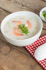 Rice porridge with shrimp in white bowl.