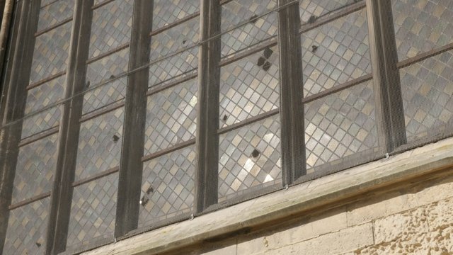 Glazing of ancient cathedral window glass with reflections of light slow tilt 4K 2160p 30fps UHD footage - Beautiful surface details of glazed window 4K 3840X2160 UltraHD tilting video 