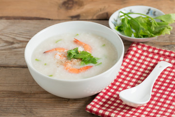Rice porridge with shrimp in white bowl.