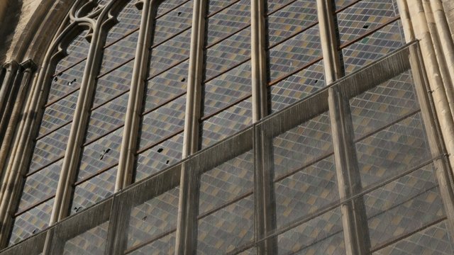 Artistic glazing of ancient cathedral window glass with reflections of light slow tilt 4K 2160p 30fps UHD footage - Beautiful surface details of glazed window 4K 3840X2160 UltraHD tilting video 