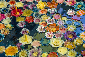 Obraz na płótnie Canvas colorful flower soaps with candle on water