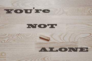 Your not alone word on wooden background