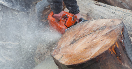 A person using a chainsaw on pretty wood