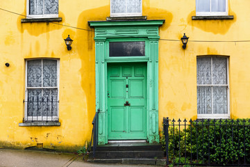 Fototapeta na wymiar Yellow house with green front door