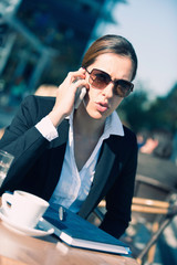 Young business woman on coffee break, talking over the phone