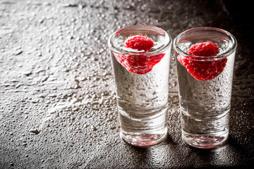 Raspberry vodka glass shot with fruit inside.