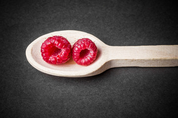 Raspberries on wooden spoon.