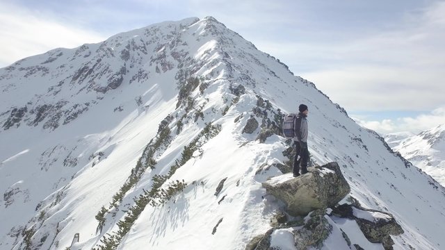 Young Man Climber Standing On Rock Edge Winter Mountain Peak Achievement Scenic Mountain Ridge Extreme Climb Success Concept