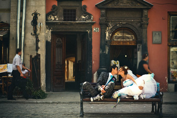 Naklejka na ściany i meble tender couple kissing on the bench on background lviv