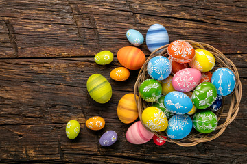 Easter eggs in basket placed on wooden planks