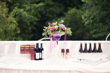 wedding table with alcohol and flowers outdoors