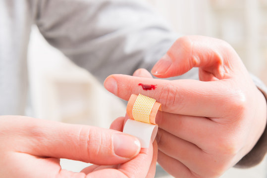 Applying adhesive bandage on finger