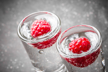 Raspberry vodka glass shot with fruit inside.