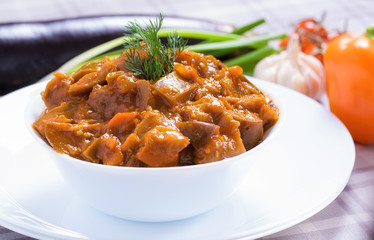 Baked eggplant with vegetables in white dish
