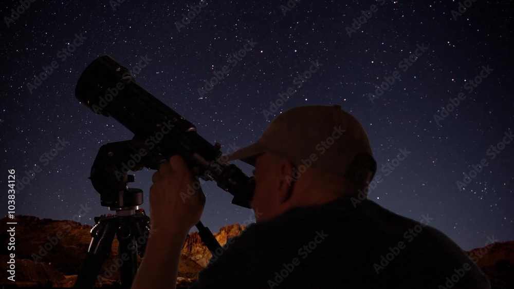 Wall mural an astronomer viewing space objects through a telescope