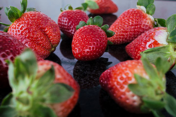 Strawberries on black table.Close up top  of strawberries arranged on a black table.Healthy Food.Fruits