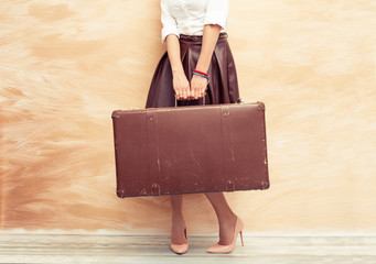 Woman holding retro suitcase 