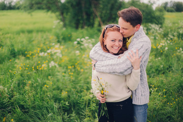 Man holding smiling woman in the meadow