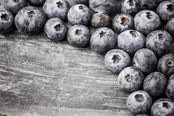 Grunge blueberries on blac surface.