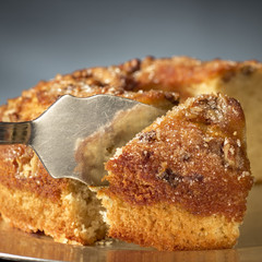 Serving a piece of walnuts bundt cake with metal shovel