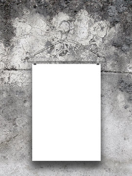 Close-up of one paper sheet with clothes hanger on stained concrete wall background