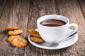 White cup of hot chocolate with homemade oat cookies.