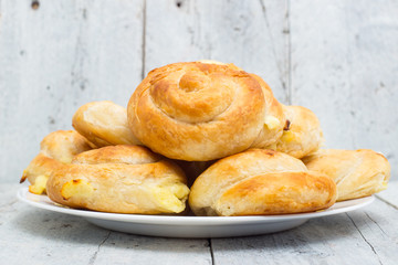 Homemade cheese bread rolls on a white wooden background