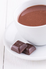 White cup of delicious hot chocolate on wooden table.