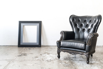 vintage armchair and frame on white wall.
