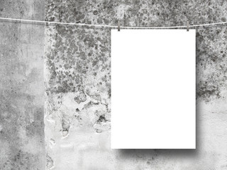 Close-up of one hanged paper sheet with pegs on weathered and moulded concrete wall background