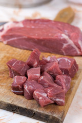 Beef steak cut into cubes. Red meat on the cutting board
