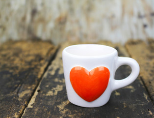 orange heart coffee cup on wooden table
