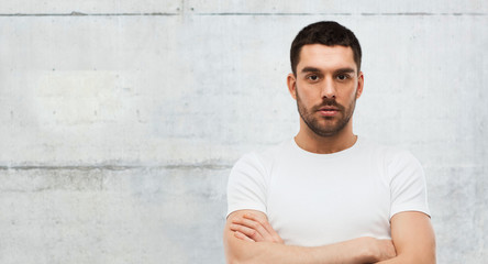 young man with crossed arms over gray background