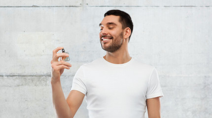 smiling man with male perfume over gray background