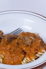 Served beef stew with macaroni in the metal plate
