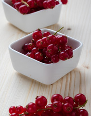 currant in white bowl on wooden table
