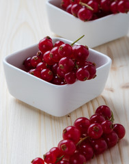currant in white bowl on wooden table